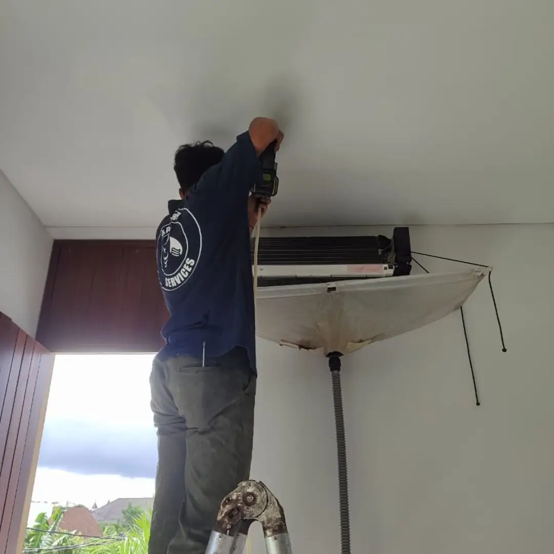 Plumber inspecting drainage and pipework for leaks in a Bali property